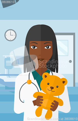 Image of Pediatrician holding teddy bear.