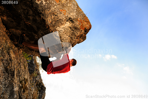 Image of Young man climbing on a wall