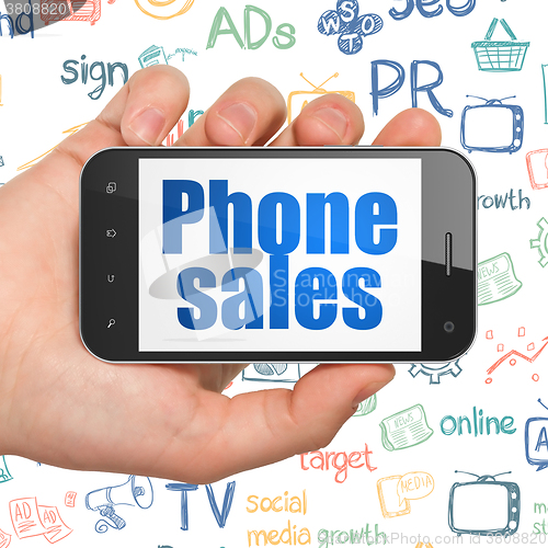 Image of Advertising concept: Hand Holding Smartphone with Phone Sales on display