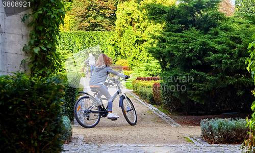 Image of Father and daughter enjoy riding on bikes in park