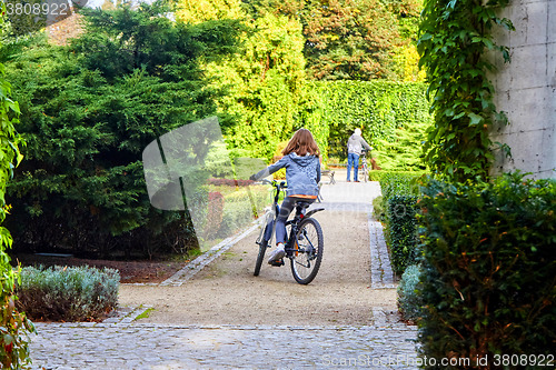 Image of Father and daughter enjoy riding on bikes in park