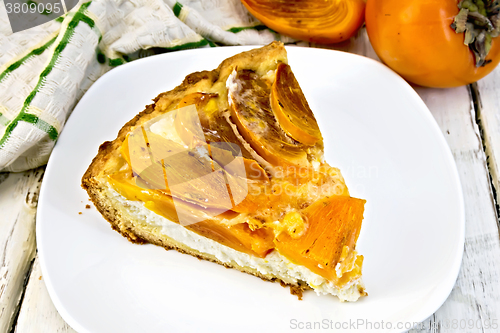 Image of Pie with curd and persimmons in plate on light board