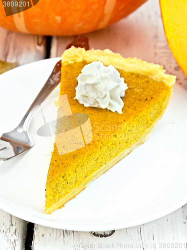 Image of Pie pumpkin with whipped cream in plate on board