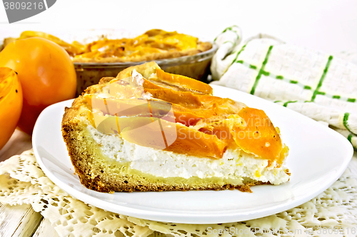 Image of Pie with curd and persimmons in plate on napkin