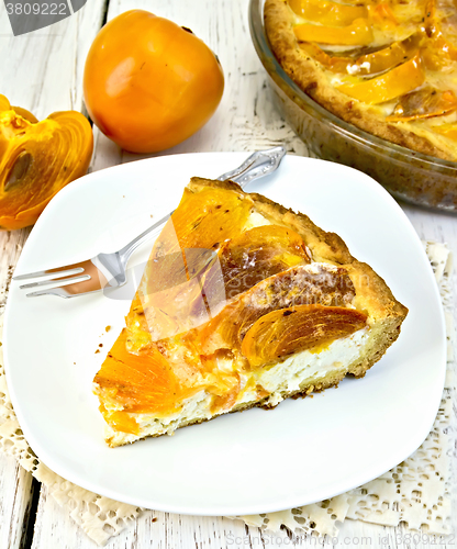 Image of Pie with curd and persimmons in plate on napkin silicone