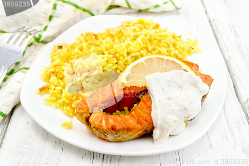 Image of Salmon with lemon and rice on board