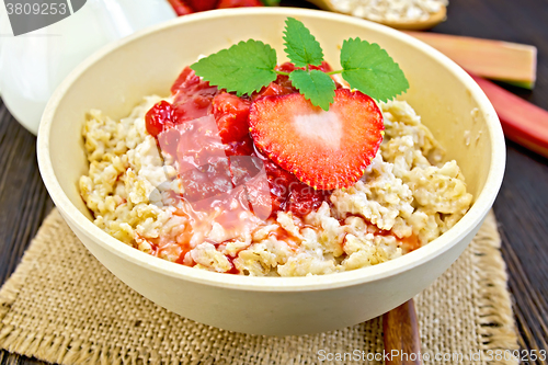 Image of Oatmeal with strawberry-rhubarb sauce on dark board