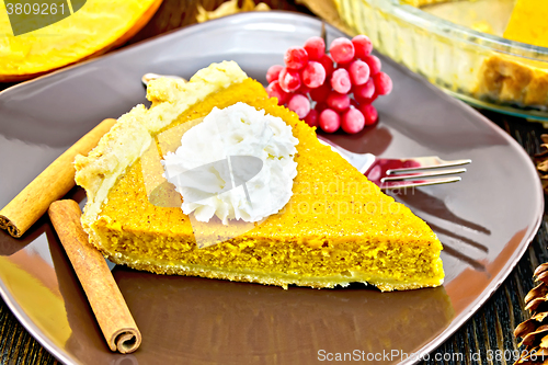 Image of Pie pumpkin in plate with cream on dark board