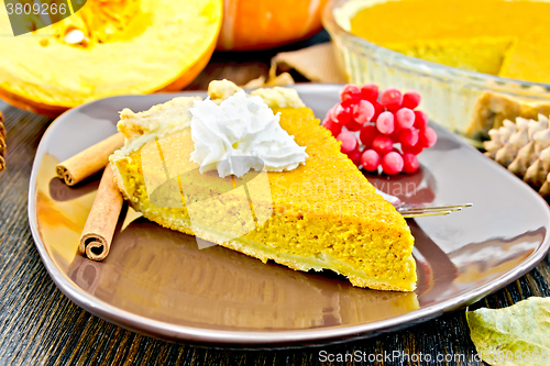 Image of Pie pumpkin in brown plate with cream on dark board