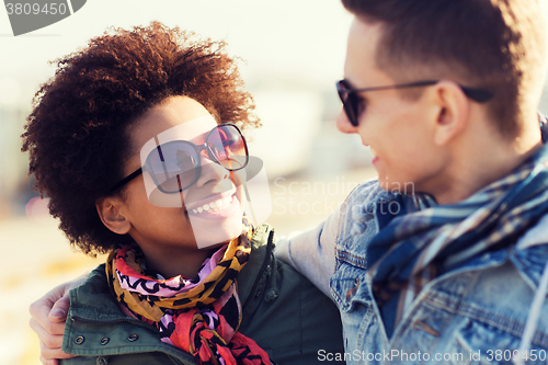 Image of happy teenage friends in shades talking outdoors