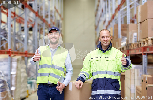 Image of men with boxes showing thumbs up at warehouse