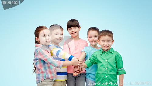 Image of happy little children with hands on top over blue