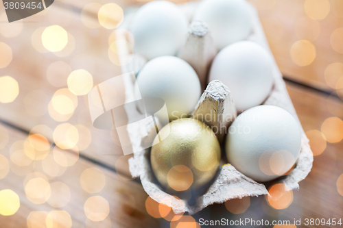 Image of close up of white and gold eggs in egg box