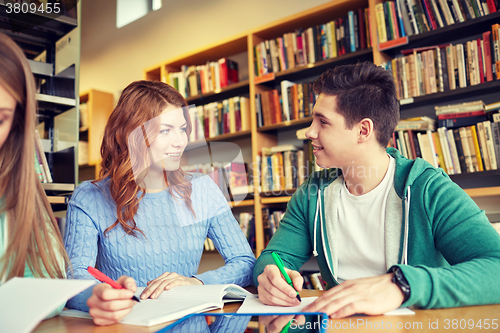 Image of happy students with tablet pc in library