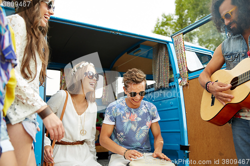 Image of happy hippie friends playing music over minivan