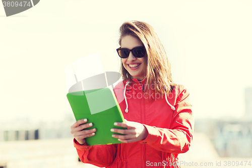 Image of happy young woman or teenage girl with tablet pc