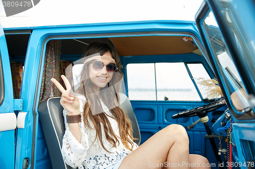 Image of happy hippie woman showing peace in minivan car