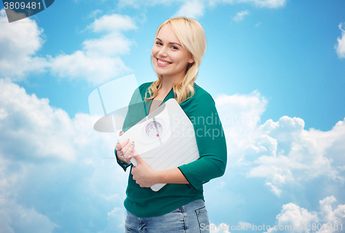 Image of smiling young woman holding scales