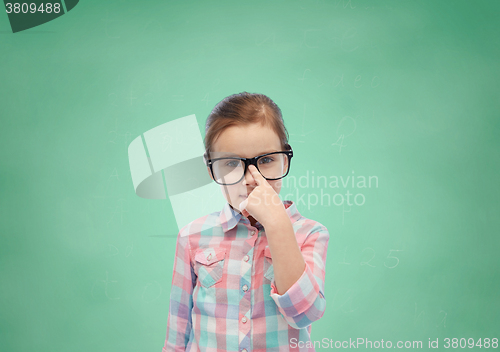 Image of happy little girl in eyeglasses over school board