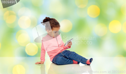 Image of smiling little baby girl playing with smartphone