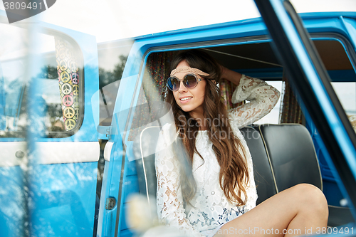 Image of smiling young hippie woman in minivan car