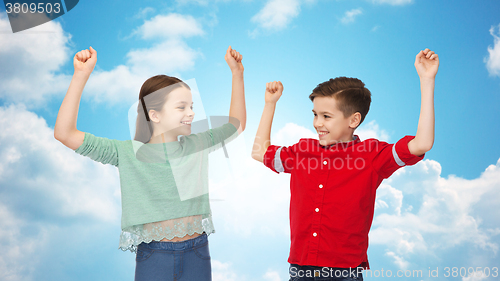 Image of happy boy and girl celebrating victory over sky