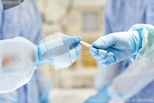 Image of close up of hands with scalpel at operation