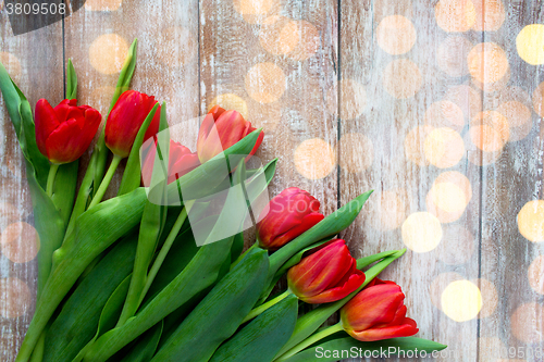 Image of close up of red tulips on wooden background