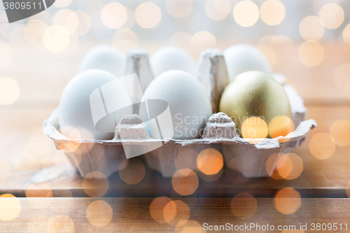 Image of close up of white and gold eggs in egg box