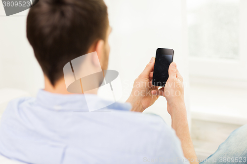 Image of close up of man with smartphone at home
