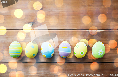 Image of close up of colored easter eggs on wooden surface