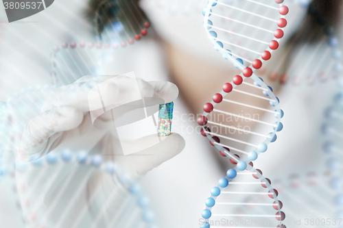 Image of close up of scientist holding pill in lab