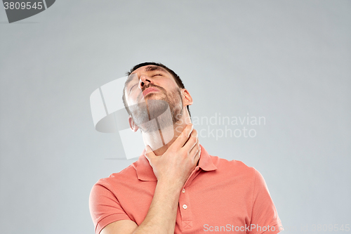 Image of man touching neck and suffering from throat pain