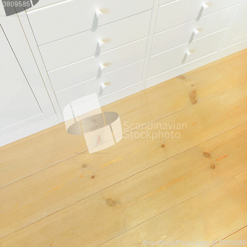 Image of White dresser on wooden floor