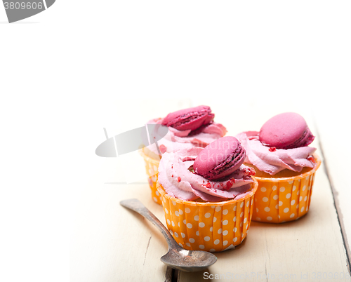 Image of pink berry cream cupcake with macaroon on top