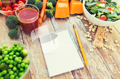 Image of close up of ripe vegetables and notebook on table
