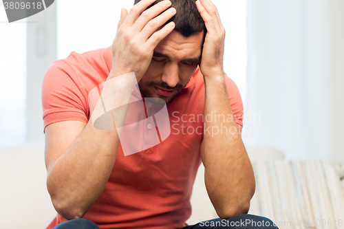Image of unhappy man suffering from head ache at home
