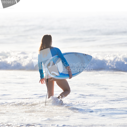 Image of Female surfer on the beach.