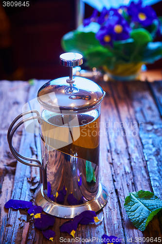 Image of Flower tea in glass pot on a wooden table. 