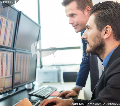 Image of Stock traders looking at computer screens.