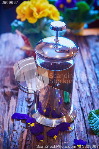 Image of Flower tea in glass pot on a wooden table. 