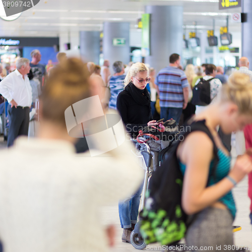 Image of Female traveler using cell phone while waiting.