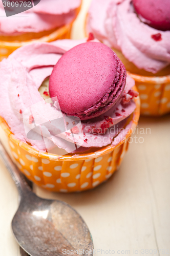 Image of pink berry cream cupcake with macaroon on top