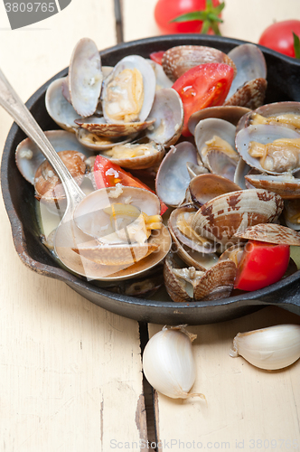 Image of fresh clams on an iron skillet