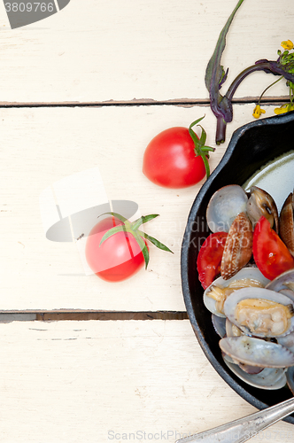 Image of fresh clams on an iron skillet