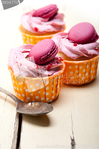 Image of pink berry cream cupcake with macaroon on top