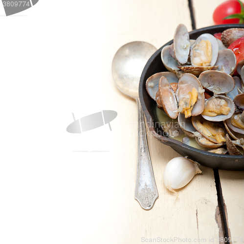 Image of fresh clams on an iron skillet