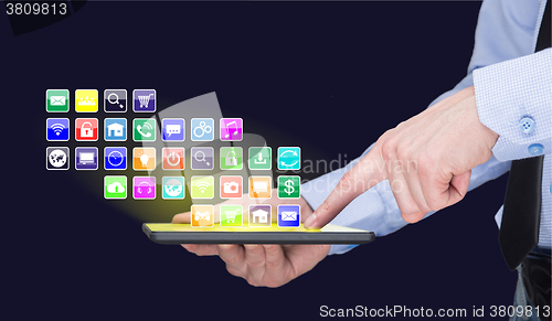 Image of Businessman holding a tablet pc with mobile applications icons on virtual screen . Internet and business concept.