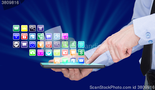 Image of Businessman holding a tablet pc with mobile applications icons on virtual screen . Internet and business concept.