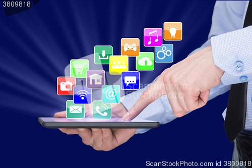 Image of Businessman holding a tablet pc with mobile applications icons on virtual screen . Internet and business concept.